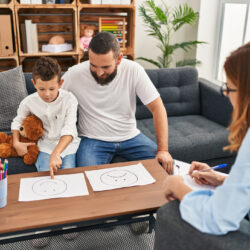 Family having psychology session choosing emotion emoji draw at psychology center